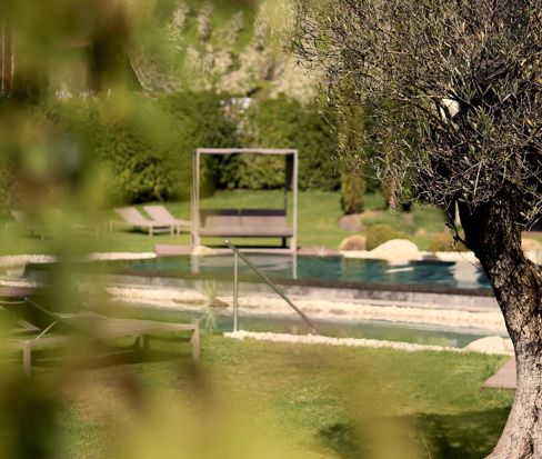 Giardino con letto a baldacchino e piscina infinity all'Hotel Anderlahn